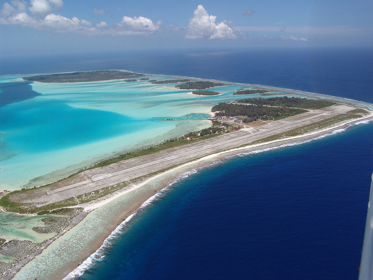 Vue aérienne de la piste de l'aéroport de Bora Bora, sur un motu entouré de lagon turquoise
