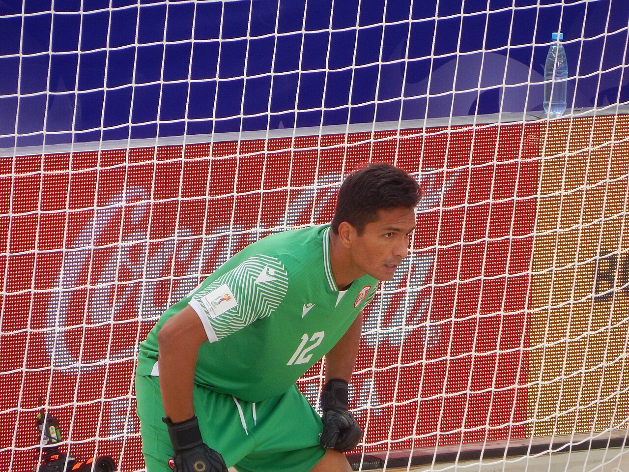 Le gardien de but tahitien en maillot vert, concentré devant son filet lors d'un match de beach soccer