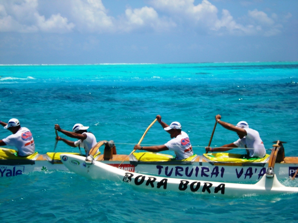Équipage de pirogue va'a à la rame dans le lagon turquoise de Bora Bora
