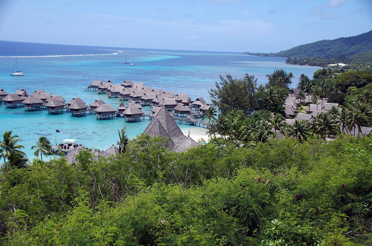 Bungalows sur pilotis et jardin d'un grand hôtel de Moorea, face au lagon turquoise