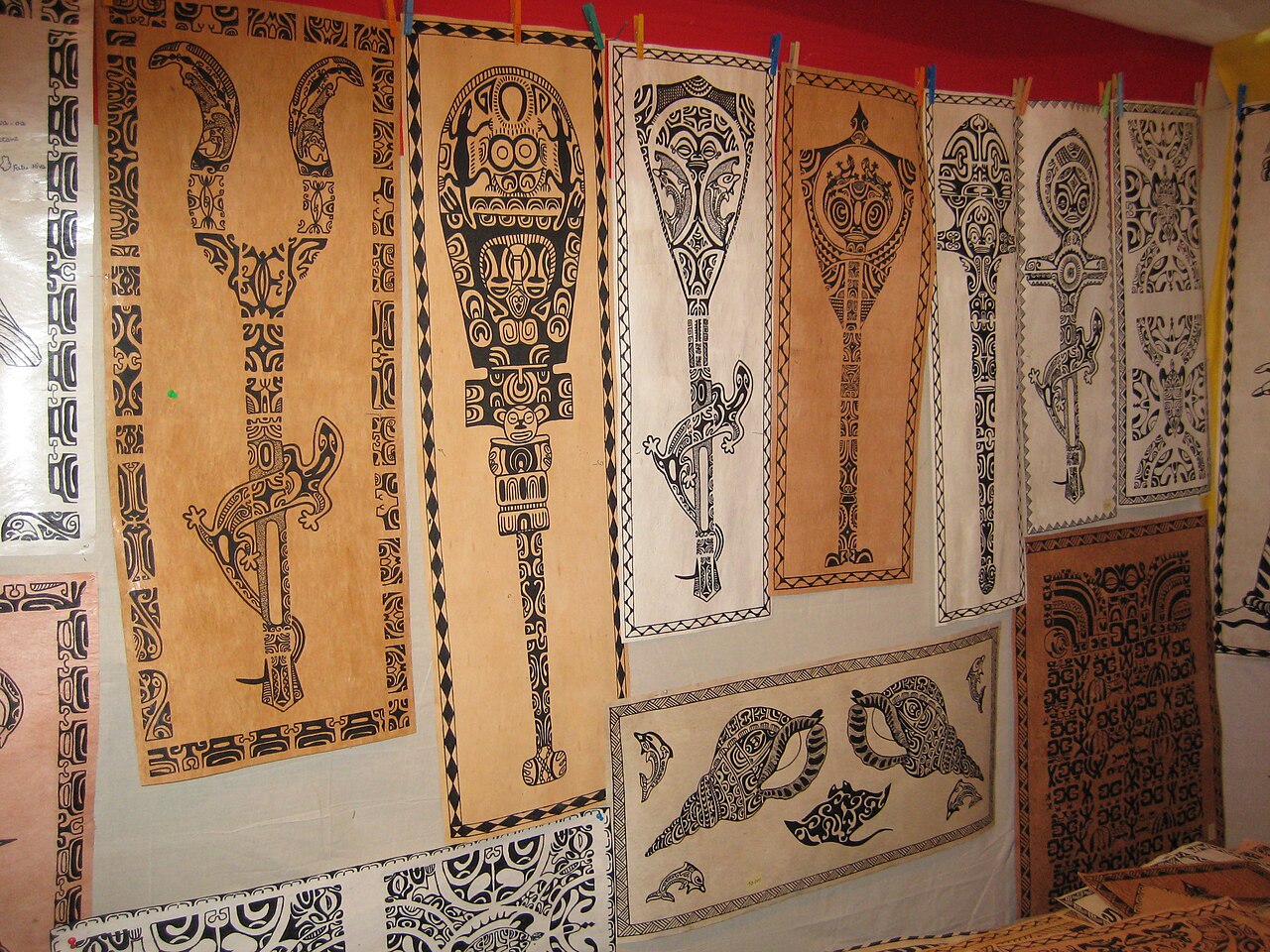 Tapas des Marquises aux motifs de tiki, lézards, raies et coquillages exposés sur un stand